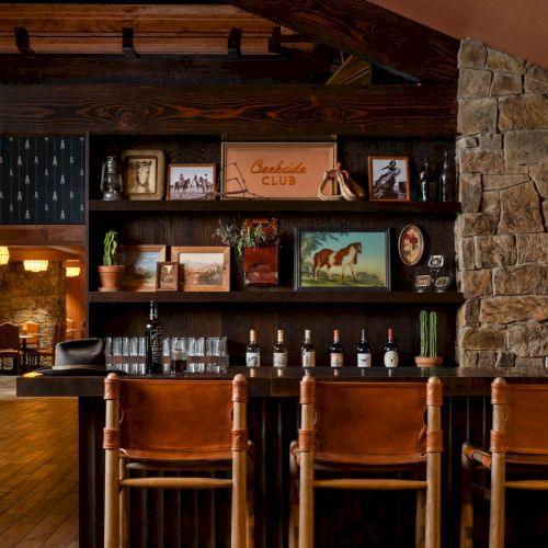 A rustic bar area with a wooden counter, shelves of bottles and glasses, and a &ldquo;Geekside Club&rdquo; sign.